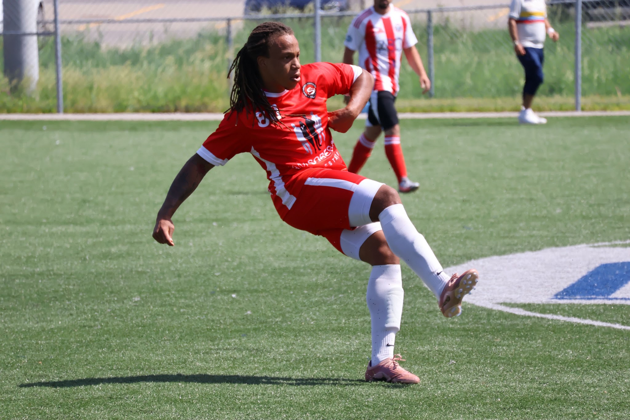 Dante Brown striking a soccer ball in a competitive match